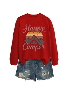Mise à plat d'un sweat rouge Happy Camper avec motif montagne et short en jean