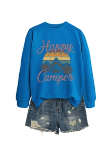 Détail du sweat Happy Camper bleu avec motif montagne et short en jean déchiré
