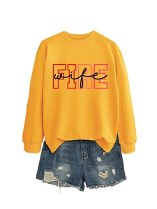 Detail of yellow round neck sweatshirt with FIRE wife print and ripped denim shorts