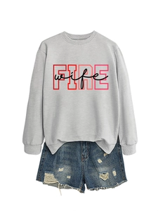 Flat lay of light grey crewneck sweatshirt with FIRE wife print and ripped denim shorts