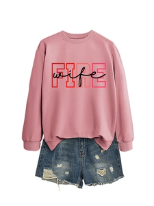 Detail view of pink crewneck sweatshirt with FIRE wife print and ripped denim shorts