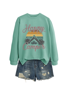 Détail du sweat Happy Camper vert menthe avec imprimé montagne et short en jean