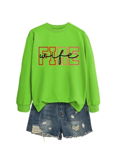 Detailed flat lay of a neon green sweatshirt with FIRE wife print and ripped denim shorts