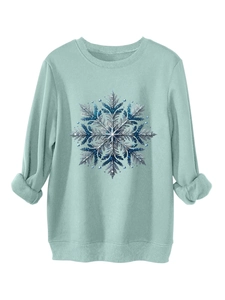 Detailopname van de mintgroene crewneck-sweatshirt met blauwe glitter sneeuwvlokprint