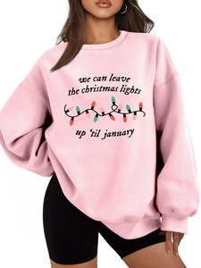 Detalle de una sudadera rosa claro con estampado de luces de Navidad de colores