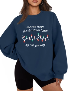 Detalle de sudadera azul marino con estampado de luces navideñas y tipografía blanca
