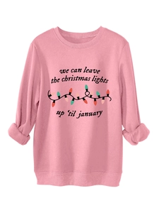 Detalle de sudadera rosa de Navidad con texto cursivo y estampado de luces de colores