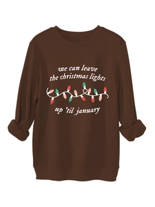 Detalle de una sudadera café con estampado de luces navideñas y letras festivas