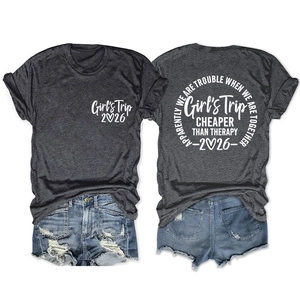 Flat lay of charcoal grey Girl's Trip 2026 t-shirt with white vintage typography print