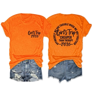 Detail view of orange t-shirt with graphic print and distressed denim shorts with frayed edges