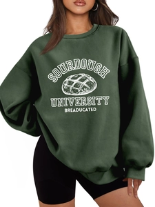 Detail of Sourdough University graphic print on a loose dark green fleece sweatshirt