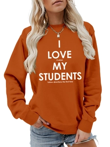 Détail d'un sweat à col rond orange avec texte blanc imprimé et poignets côtelés