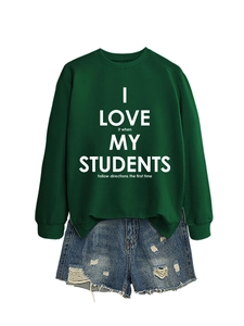 Détail d'un sweat vert foncé avec typographie éducative et short en jean vieilli