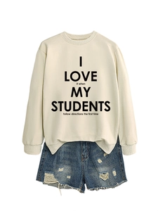 Détail du sweat-shirt blanc à texte et texture du short en jean bleu délavé