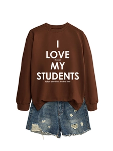 Détail d'un sweat marron foncé avec inscription blanche et mini-short en jean délavé