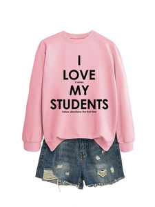 Détail d'un sweat rose à message avec un mini short en jean déchiré pour femme