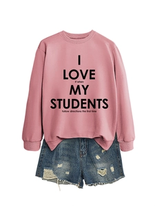 Détail d'un sweat-shirt rose avec impression de texte noir et short en jean vieilli