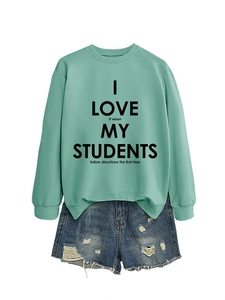 Mise à plat d'un sweat vert menthe à imprimé lettres et d'un short en jean déchiré