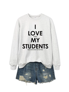 Détail d'un sweat gris à col rond avec impression de lettres noires et tissu en coton doux