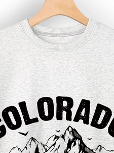 Close-up of ribbed crewneck and vintage Colorado mountain print on heather grey sweatshirt