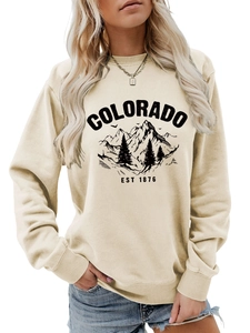 Detailed view of beige crewneck sweatshirt with black Colorado mountain and forest print