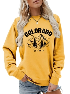 Detail of yellow Colorado crewneck sweatshirt featuring forest and mountain graphic print