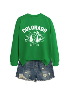Detailed close-up of Colorado EST 1876 mountain print on green crewneck sweatshirt