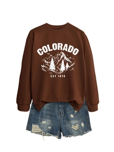 Flat lay of brown Colorado Est graphic sweatshirt paired with distressed denim shorts