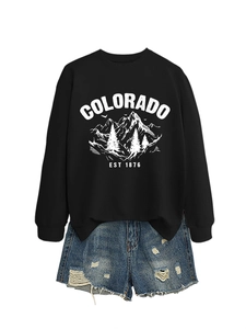 Flat lay of a Colorado mountain print sweatshirt paired with distressed denim shorts