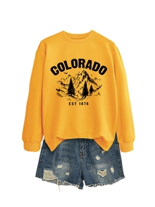 Flat lay of a yellow Colorado EST 1876 sweatshirt and distressed denim shorts