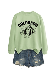 Flat lay of light green Colorado sweatshirt paired with distressed denim shorts
