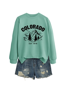 Flat lay of a mint green sweatshirt with Colorado print and distressed denim shorts