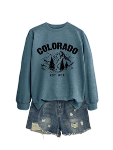 Detail of greyish blue Colorado sweatshirt with forest print and distressed denim shorts