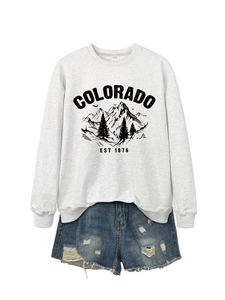 Flat lay of a grey Colorado graphic sweatshirt paired with distressed denim shorts