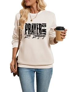 Detail of cream sweatshirt with black gothic text and ribbed cuffs on female model