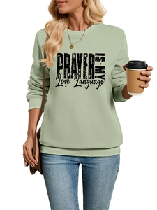 Detail of sage green sweatshirt featuring prayer is my love language black text