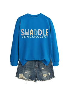 Flat lay of bright blue crewneck sweatshirt and distressed denim shorts with frayed hems