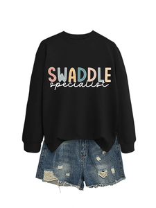 Flat lay detail of black graphic sweatshirt and distressed denim shorts with lettering