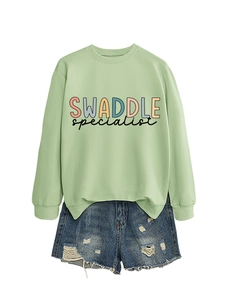 Flat lay of mint green crewneck sweatshirt featuring SWADDLE graphic print design