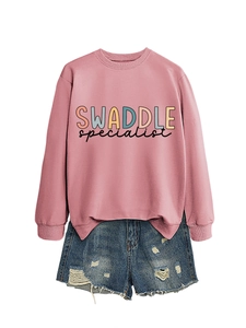 Flat lay of pink letter print sweatshirt paired with distressed denim shorts on white background