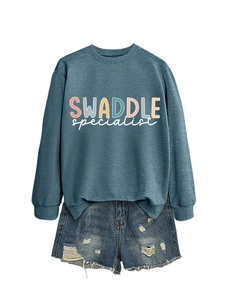 Detail of blue crewneck sweatshirt with letter print paired with ripped denim shorts