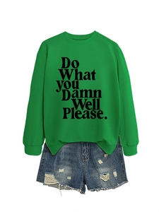 Detailed flat lay of a green long-sleeve sweatshirt with black graphic text and denim shorts