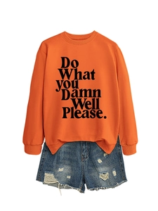 Detail of orange sweatshirt with black 'Do What YOU Damn Well Please' text and denim shorts