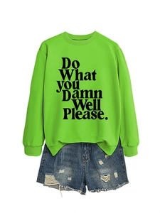 Flat lay of neon green crewneck sweatshirt with black text and ripped denim shorts
