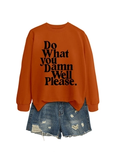 Detail of burnt orange sweatshirt with text print and distressed denim shorts