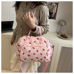 Detail van roze corduroy lunchtas met aardbeienprint en verstelbare schouderband