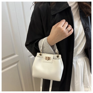 Détail du sac seau blanc perle avec grain de litchi texturé et boucle en métal doré