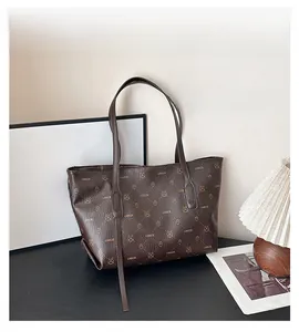 Dettaglio della borsa tote marrone scuro con monogramma orso e manici lunghi
