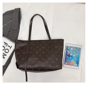 Grande borsa tote marrone scuro che mostra capienza con iPad e oggetti quotidiani