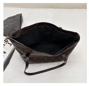 Interior view of large plaid tote bag showing black lining and open pocket